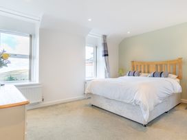 A bedroom with a bed and windows at Groeslon Uchaf in Caernarfon