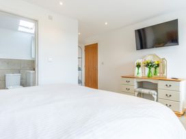 A bedroom with a bed and a television at Groeslon Uchaf in Caernarfon