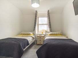 A bedroom with two beds and a nightstand at Groeslon Uchaf in Caernarfon