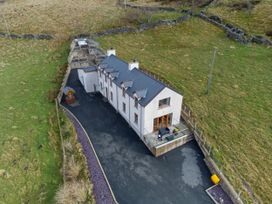 An exterior view of a house with a deck and garden at Groeslon Uchaf in Caernarfon