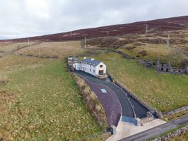 A house with a driveway surrounded by landscape at Groeslon Uchaf in Caernarfon