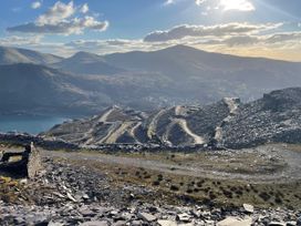 A view of mountains and a path leading to a lake at Groeslon Uchaf in Caernarfon
