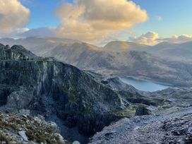 A landscape view of a quarry and lake with mountains in the background at Groeslon Uchaf Caernarfon