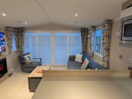 A living room with a sofa and microwave at Lighthouse Lodge in Mablethorpe
