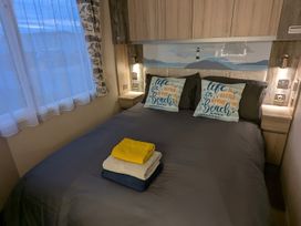 A bedroom with a bed and towels at Lighthouse Lodge in Mablethorpe