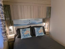 A bedroom with a bed and decorative pillows at Lighthouse Lodge in Mablethorpe