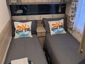 A bedroom with two single beds and decorative pillows at Lighthouse Lodge in Mablethorpe