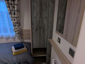 A bedroom with a bed and wardrobe at Lighthouse Lodge in Mablethorpe
