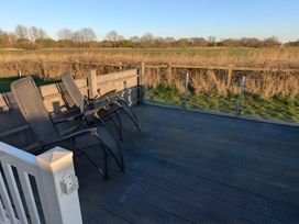 An outdoor area with chairs on a deck at Lighthouse Lodge in Mablethorpe