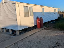 A mobile home with gas cylinders and a pathway in Mablethorpe