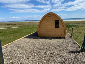 An outdoor view of a wooden pod with a window at Kirkapol Beach Pod - Flow Isle of Tiree