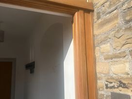 A hallway with a wooden door and coat hooks at 4 Bickington Road Barnstaple