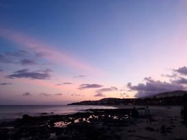 A beach scene with people walking near the water at 4 Bickington Road in Barnstaple