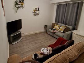 A living room with a sofa and a TV at Blue Haven in Penmaenmawr