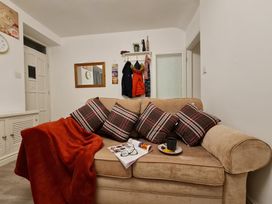 A living room with a sofa and a coat rack at Blue Haven in Penmaenmawr