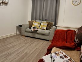 A living room with a sofa and cushions at Blue Haven in Penmaenmawr