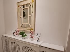 A hallway with a mirror and decorative plants at Blue Haven Penmaenmawr