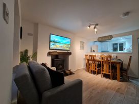 A living room featuring a sofa, television, and dining table at Blue Haven in Penmaenmawr