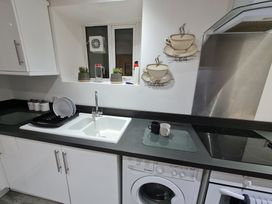 A kitchen with sink and washing machine at Blue Haven in Penmaenmawr