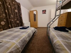 A bedroom with a bunk bed and single bed at Blue Haven in Penmaenmawr