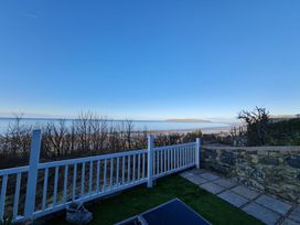 A view of the sea and shore from a fenced area at Blue Haven in Penmaenmawr