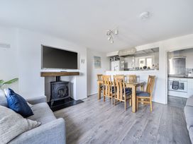 A living room with a television and dining area at Blue Haven in Penmaenmawr