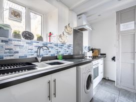 A kitchen with a sink and washing machine at Blue Haven in Penmaenmawr