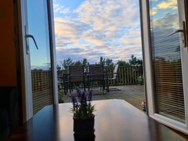 A table with a flower pot and outdoor furniture at Sea View Escape Penmaenmawr