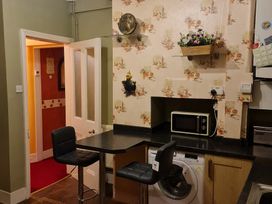A kitchen with a washing machine and microwave at Sea View Escape in Penmaenmawr