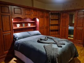 A bedroom with a bed and wooden furniture at Sea View Escape in Penmaenmawr