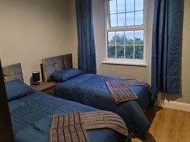 A bedroom with two single beds and a window at Sea View Escape in Penmaenmawr