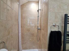 A shower with a showerhead and towel in the bathroom at Sea View Escape in Penmaenmawr