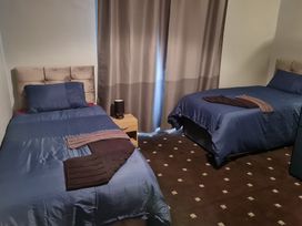 A bedroom with two beds and a bedside table at Sea View Escape in Penmaenmawr