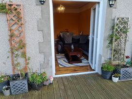 A living room with a table and seating visible from an outdoor area at Sea View Escape in Penmaenmawr