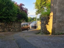 A view of a driveway with vehicles and a gate at Sea View Escape in Penmaenmawr