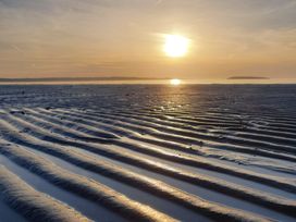 A beach with rippled sand and sunset at Sea View Escape Penmaenmawr