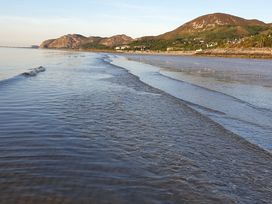 A beach scene with water and hills in the background at Sea View Escape Penmaenmawr