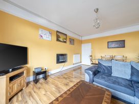 A living room with a television and dining area at Sea View Escape in Penmaenmawr