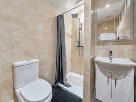 A bathroom featuring a shower, toilet, and sink at Sea View Escape Penmaenmawr