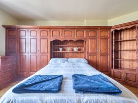 A bedroom with a bed and wooden furniture at Sea View Escape in Penmaenmawr