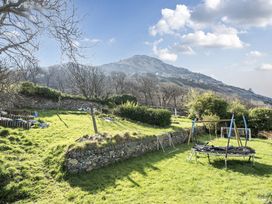 A garden with a trampoline and swing set at Sea View Escape in Penmaenmawr