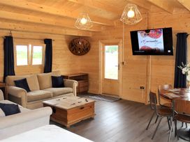 A living room with a sofa, table, and television at Cotswold Nights Away 1 in Evesham