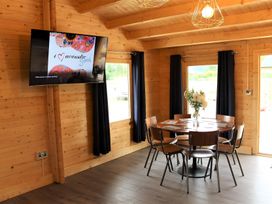 A dining room with a television and table at Cotswold Nights Away 1 in Evesham