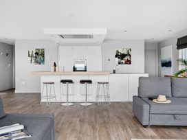 A kitchen with bar stools and a kitchen island at Huxham View and Annex in Stoke Canon