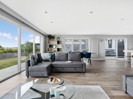 A living room with a sofa, coffee table and dining area at Huxham View and Annex Stoke Canon