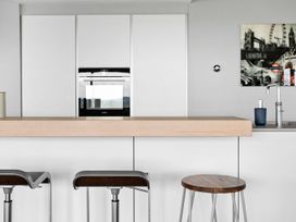 A kitchen with a countertop and bar stools at Huxham View and Annex Stoke Canon