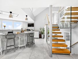 A kitchen with stairs and bar stools at Huxham View and Annex Stoke Canon