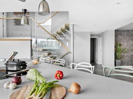 A kitchen with a cooking area and a staircase at Huxham View and Annex Stoke Canon