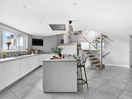 A kitchen with an island and stools at Huxham View and Annex Stoke Canon