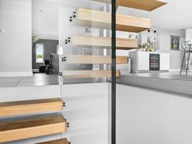 A staircase with wooden steps leading to a kitchen at Huxham View and Annex Stoke Canon